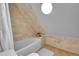 Bright bathroom showcases a tiled wall, soaking tub, and unique oval window at 1208 S Pennsylvania St, Denver, CO 80210
