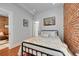 Bright bedroom featuring exposed brick wall, hardwood floors, and lots of natural light at 1208 S Pennsylvania St, Denver, CO 80210