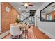 Open dining room features a brick wall, modern metal staircase, and wood floors at 1208 S Pennsylvania St, Denver, CO 80210