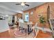 Dining room area featuring a brick wall, ceiling fan, wood floors, and bright natural light at 1208 S Pennsylvania St, Denver, CO 80210