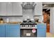 Kitchen featuring stainless steel range, white upper and blue lower cabinets, and view of the dining room at 1208 S Pennsylvania St, Denver, CO 80210