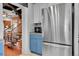 Kitchen with stainless steel appliances, white and blue cabinets, and view of modern staircase at 1208 S Pennsylvania St, Denver, CO 80210
