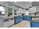 Eat-in kitchen with white and blue cabinets, stainless steel appliances, and neutral tile floors at 1208 S Pennsylvania St, Denver, CO 80210