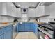 Kitchen showcasing white and blue cabinets, stainless steel appliances, and bright natural light at 1208 S Pennsylvania St, Denver, CO 80210