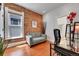 Cozy living room featuring exposed brick wall, hardwood floors, and a modern loveseat at 1208 S Pennsylvania St, Denver, CO 80210