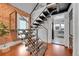 Modern metal staircase beside a brick wall and hardwood floors leads up to the second floor at 1208 S Pennsylvania St, Denver, CO 80210