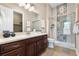 Bathroom featuring dark wood vanity, stylish mirror, and shower with decorative tile at 22609 E Eads Cir, Aurora, CO 80016