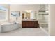 This bathroom features a soaking tub, glass shower, and dual sink vanity with a white and brown color palette at 22609 E Eads Cir, Aurora, CO 80016