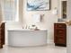 Relaxing bathroom featuring a standalone soaking tub, wood cabinets, and tile floors with natural light at 22609 E Eads Cir, Aurora, CO 80016