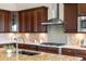 The chef's kitchen offers custom cabinets, granite counters, mosaic backsplash, and stainless KitchenAid appliances at 22609 E Eads Cir, Aurora, CO 80016