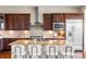 Modern kitchen boasts custom cabinets, a stainless range hood, and granite countertops with seating at 22609 E Eads Cir, Aurora, CO 80016