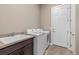Well-lit laundry room with modern washer and dryer, sink, and storage space at 22646 E Glidden Dr, Aurora, CO 80016