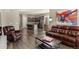 Inviting living room with hardwood floors, brown leather furniture, and an open concept kitchen in the background at 22646 E Glidden Dr, Aurora, CO 80016
