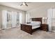 Bright main bedroom featuring a large bed, carpet, and multiple windows with natural light at 22646 E Glidden Dr, Aurora, CO 80016