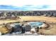 Community aerial view featuring pool, field, clubhouse, and landscaped areas at 11442 Booth Falls Ct, Parker, CO 80134