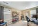 Bedroom with beige walls, two windows, and a large dark bookcase displaying books and collectables at 11442 Booth Falls Ct, Parker, CO 80134