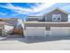 Townhome exterior view showing a two-car garage with light gray paint and a blue sky backdrop at 11442 Booth Falls Ct, Parker, CO 80134