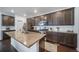 Spacious kitchen featuring dark cabinetry, subway tile backsplash, stainless steel appliances, and a granite island at 11442 Booth Falls Ct, Parker, CO 80134