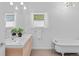 Bright bathroom featuring double sinks, a clawfoot tub, and lots of natural light at 2643 N Marion St, Denver, CO 80205