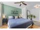 Stylish bedroom features a light green accent wall, wood floors and matching nightstands at 2643 N Marion St, Denver, CO 80205