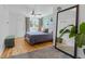 A well lit bedroom features hardwood floors, a queen bed, and a large mirror at 2643 N Marion St, Denver, CO 80205