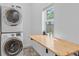 Bright laundry room with a stackable washer and dryer, and a folding table at 2643 N Marion St, Denver, CO 80205