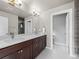 Bright bathroom featuring a double sink vanity, neutral color palette, and a glass shower with tile surround at 4529 Vrain St, Denver, CO 80212