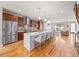 Spacious kitchen with stainless steel appliances, expansive island, and hardwood floors leading to the living area at 4529 Vrain St, Denver, CO 80212