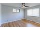 Bright bedroom with hardwood floors, ceiling fan, and ample natural light from two windows at 4580 Balsam St, Wheat Ridge, CO 80033