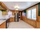 Modern kitchen with stainless steel refrigerator, wood cabinetry and ample natural light at 4580 Balsam St, Wheat Ridge, CO 80033