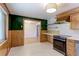 Charming kitchen with stainless steel oven, stylish backsplash, and wood-paneled walls at 4580 Balsam St, Wheat Ridge, CO 80033