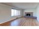 Bright living room with hardwood floors, large window, and a brick fireplace, perfect for gatherings at 4580 Balsam St, Wheat Ridge, CO 80033