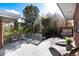 This backyard boasts a covered hot tub, patio, lounge chairs, greenery, and exterior brick at 7000 Highland Dr, Lakewood, CO 80214
