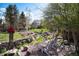 Beautiful backyard featuring a peaceful stream, Adirondack chairs, and lush landscaping at 7000 Highland Dr, Lakewood, CO 80214