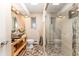 The neutral bathroom features a clear glass enclosed shower, vessel sink, wood vanity, and window at 7000 Highland Dr, Lakewood, CO 80214