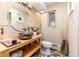 Bathroom with a round mirror, vessel sink, modern fixtures, and stone-look tile at 7000 Highland Dr, Lakewood, CO 80214