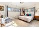 This bright bedroom has windows, an accent chair, decorative rug, and a bed with colorful pillows at 7000 Highland Dr, Lakewood, CO 80214