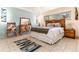 Bright bedroom featuring a bed with a wooden headboard, side table, rug, and accent chair at 7000 Highland Dr, Lakewood, CO 80214