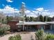 Charming brick home featuring attached carport and two-car garage with mature trees surrounding the residence at 7000 Highland Dr, Lakewood, CO 80214