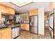 Kitchen area with stainless steel refrigerator, dishwasher, light wood cabinets, and ample counter space at 7000 Highland Dr, Lakewood, CO 80214