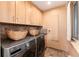 Laundry room with washer, dryer, overhead cabinets, and a tiled backsplash at 7000 Highland Dr, Lakewood, CO 80214