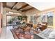 Bright living room with exposed beam ceiling, floor-to-ceiling windows, and ample seating, perfect for entertaining at 7000 Highland Dr, Lakewood, CO 80214