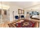 Inviting living room with accent chairs, decorative rug, and view into primary bedroom at 7000 Highland Dr, Lakewood, CO 80214