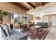Spacious living room with beamed ceiling, tile floors, and large windows offering great natural light and views of backyard at 7000 Highland Dr, Lakewood, CO 80214