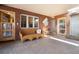 Cozy sunroom with brick walls, comfortable seating, and unique stained-glass doors that create a warm and inviting space at 7000 Highland Dr, Lakewood, CO 80214