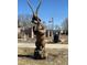 Wood carving of a bear holding an eagle near a park and flagpole at 7208 Dolores Ave, Frederick, CO 80530