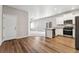 Bright, open-concept kitchen featuring stainless steel appliances, white cabinets and wood flooring at 7208 Dolores Ave, Frederick, CO 80530