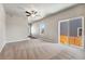 Spacious living room with plush carpeting, ceiling fan, and sliding glass doors to the backyard at 7208 Dolores Ave, Frederick, CO 80530