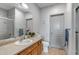 Well-lit bathroom with a wood vanity, framed mirror, toilet, and glass-enclosed shower at 837 E 98Th Ave # 403, Thornton, CO 80229