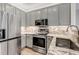 Modern kitchen featuring granite countertops, stainless steel appliances and gray cabinets at 837 E 98Th Ave # 403, Thornton, CO 80229